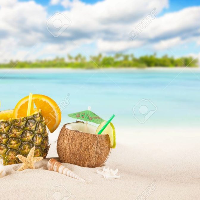 Sandy tropical beach with palm island and summer drinks